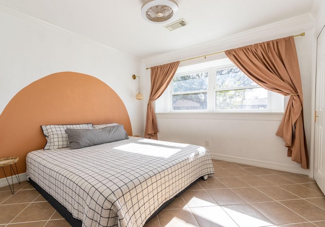 bedroom with tile patterned flooring, ornamental molding, and multiple windows