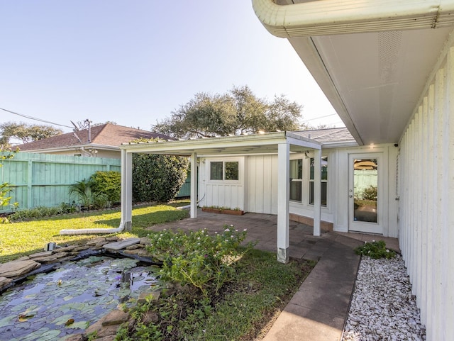 entrance to property featuring a patio area and a yard