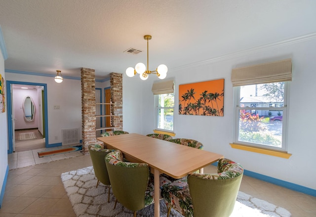 dining room featuring tile patterned flooring, a textured ceiling, an inviting chandelier, and ornamental molding