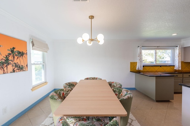 tiled dining area with a healthy amount of sunlight, crown molding, a chandelier, and a textured ceiling