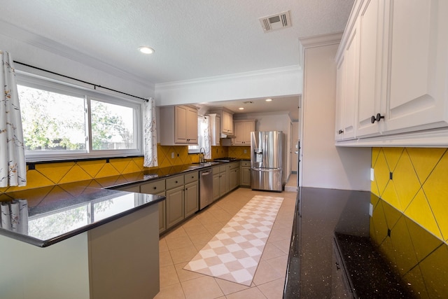 kitchen featuring sink, light tile patterned floors, crown molding, and appliances with stainless steel finishes