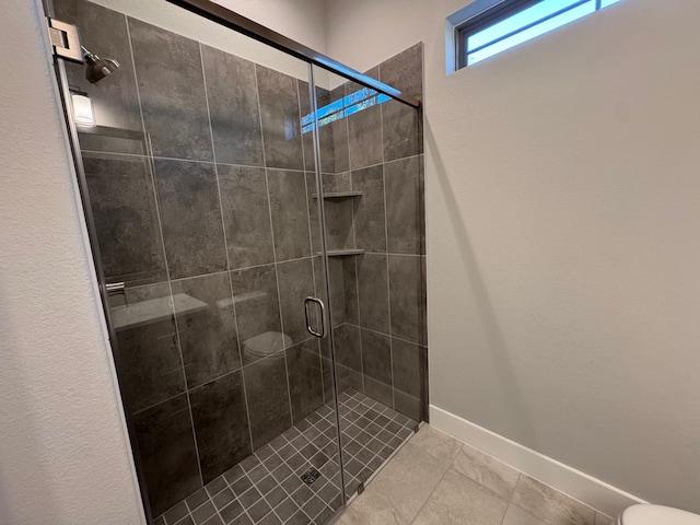 bathroom featuring walk in shower, tile patterned floors, and toilet