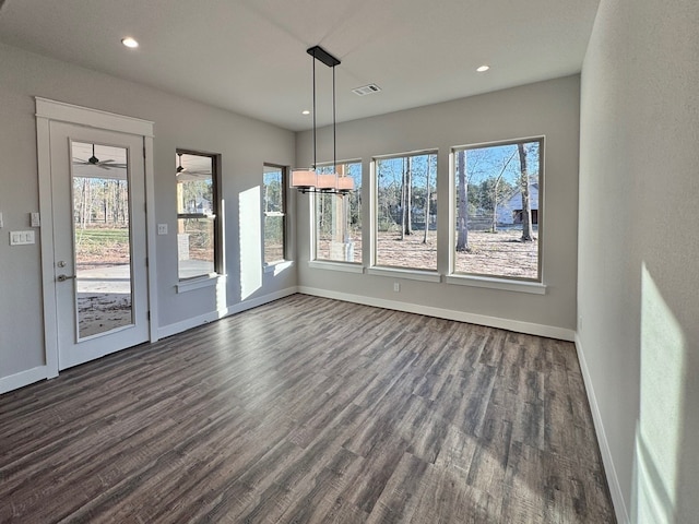 unfurnished dining area featuring ceiling fan and dark hardwood / wood-style floors