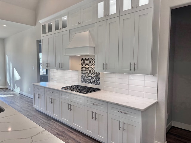 kitchen featuring premium range hood, white cabinetry, dark wood-type flooring, and light stone counters