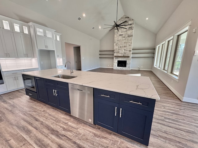 kitchen featuring dishwasher, sink, ceiling fan, built in microwave, and white cabinetry