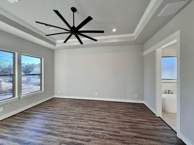 unfurnished bedroom with dark wood-type flooring, crown molding, ceiling fan, connected bathroom, and a tray ceiling