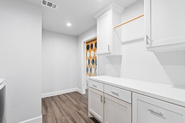 kitchen with hardwood / wood-style flooring and white cabinetry