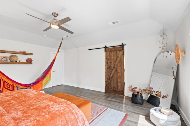 bedroom featuring ceiling fan, a barn door, wood-type flooring, and lofted ceiling