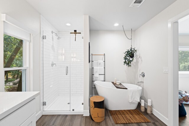 bathroom featuring vanity, wood-type flooring, and shower with separate bathtub