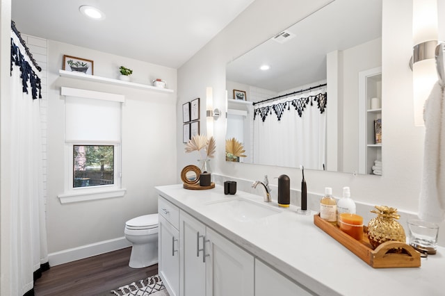 bathroom featuring wood-type flooring, vanity, and toilet