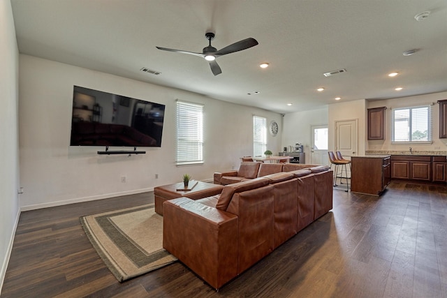 living room featuring ceiling fan and dark hardwood / wood-style flooring