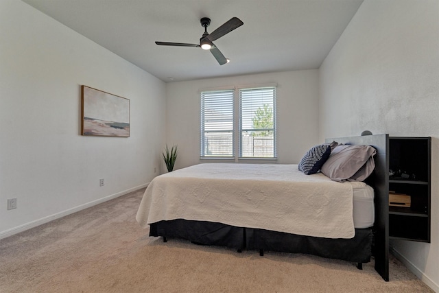 bedroom featuring light carpet, ceiling fan, and baseboards