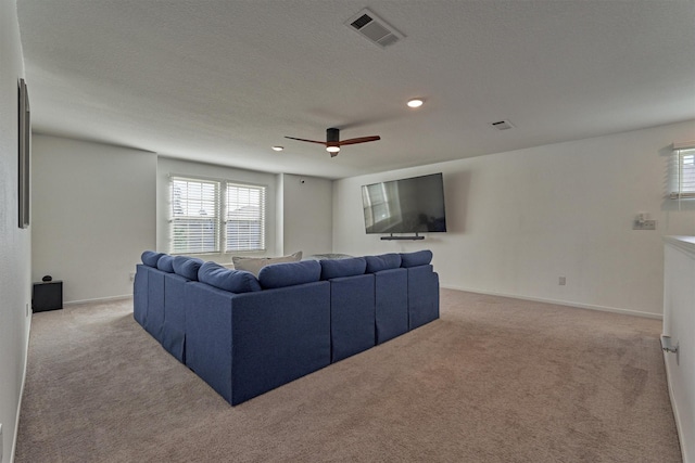 living area with light carpet, baseboards, visible vents, ceiling fan, and a textured ceiling