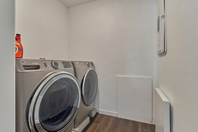 clothes washing area with washer and clothes dryer and dark hardwood / wood-style flooring