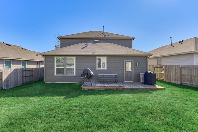 rear view of property featuring a yard and a deck