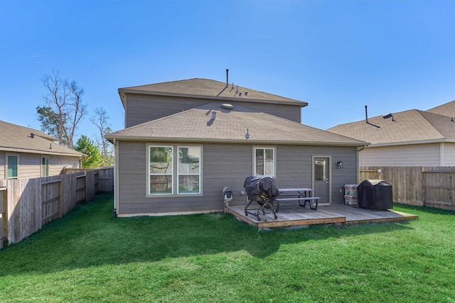 back of house featuring a lawn and a wooden deck