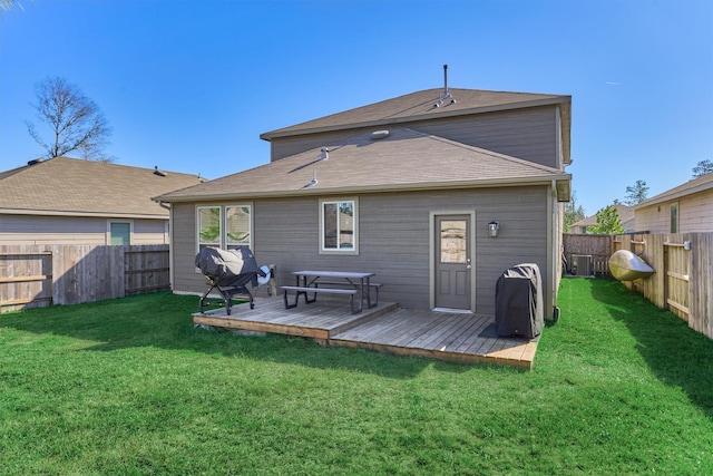 rear view of property featuring a yard and a wooden deck