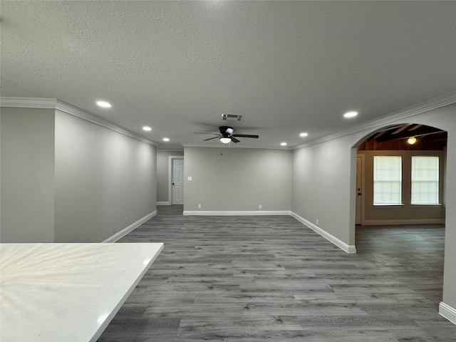 spare room featuring a textured ceiling, light hardwood / wood-style flooring, ceiling fan, and ornamental molding