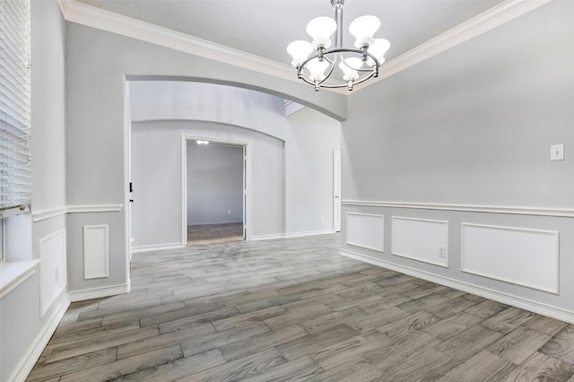 unfurnished dining area featuring a chandelier, light hardwood / wood-style floors, and ornamental molding