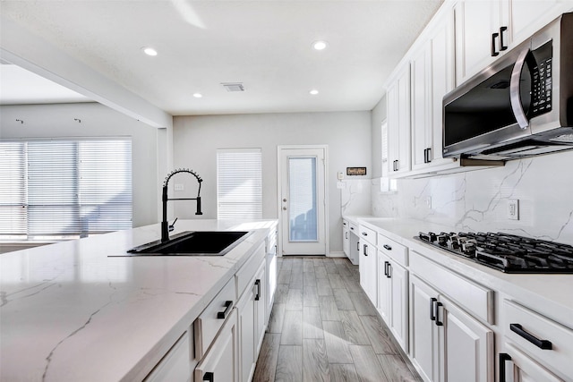 kitchen with sink, white cabinetry, and gas cooktop