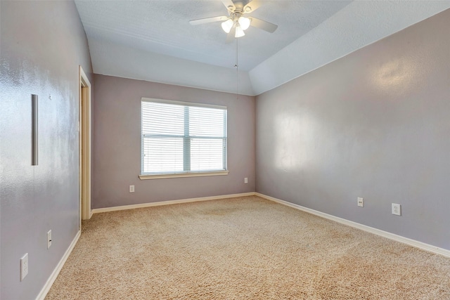 spare room featuring lofted ceiling, light colored carpet, and ceiling fan