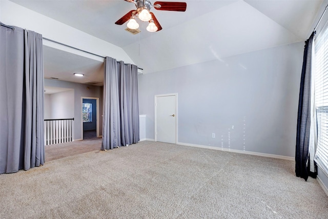 carpeted spare room featuring lofted ceiling, ceiling fan, and plenty of natural light