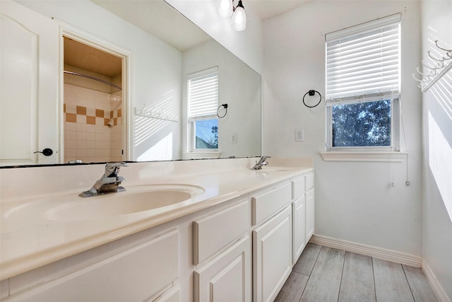 bathroom with a tile shower and vanity