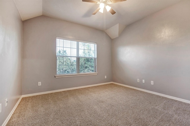 spare room with ceiling fan, vaulted ceiling, and carpet flooring