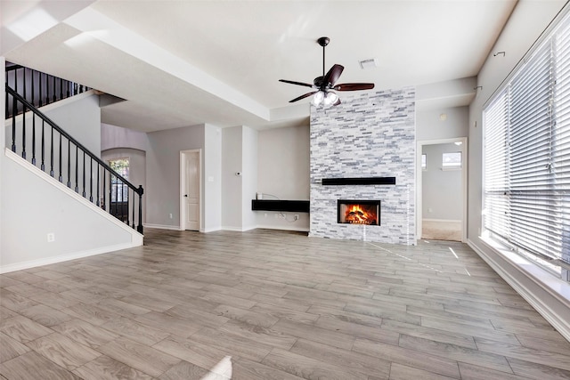 unfurnished living room with a fireplace, a healthy amount of sunlight, and light hardwood / wood-style flooring