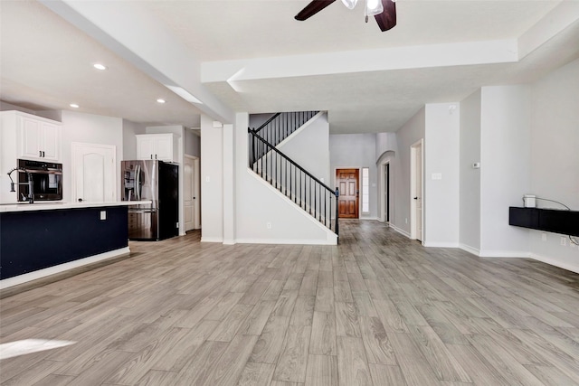 unfurnished living room with light hardwood / wood-style floors and ceiling fan