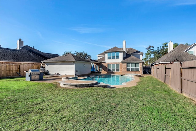 rear view of house with a patio area, a lawn, and a fenced in pool