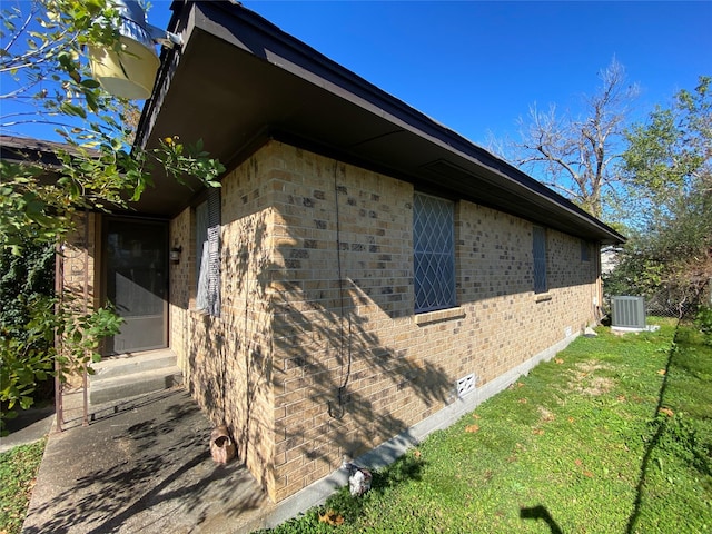 view of property exterior with central air condition unit and a lawn