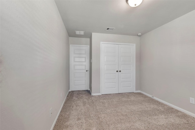 unfurnished bedroom with a closet and light carpet