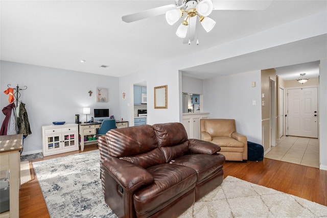 living room with hardwood / wood-style flooring and ceiling fan