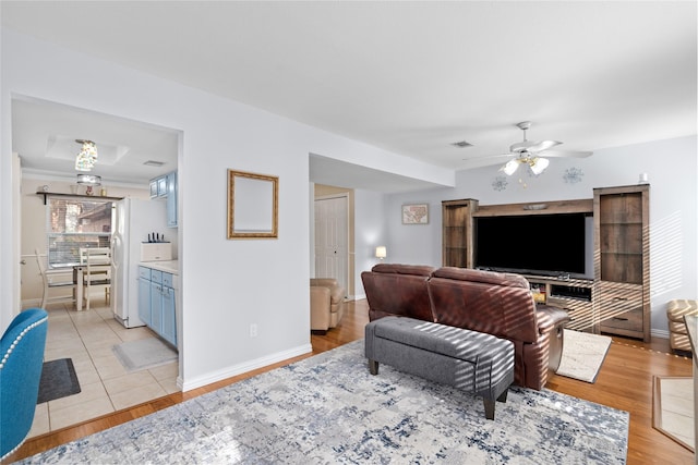 tiled living room with ceiling fan