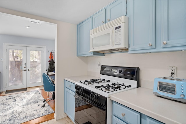 kitchen with french doors, light tile patterned flooring, white appliances, and blue cabinets