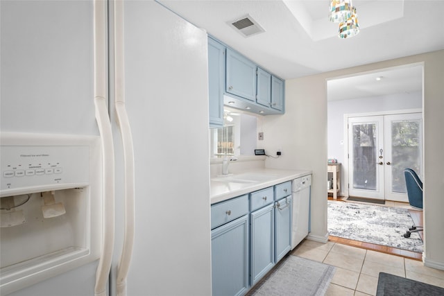 kitchen with french doors, white appliances, sink, blue cabinetry, and light tile patterned floors