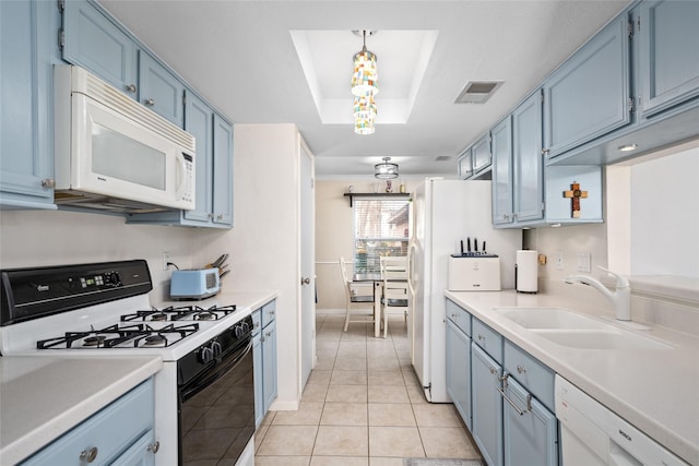 kitchen with white appliances, blue cabinets, sink, light tile patterned floors, and decorative light fixtures