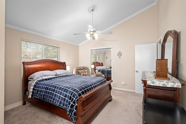 carpeted bedroom with ceiling fan, lofted ceiling, ornamental molding, and a closet