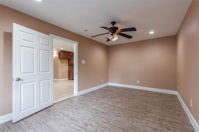 spare room featuring ceiling fan and light hardwood / wood-style flooring