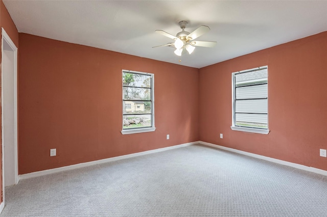 empty room with ceiling fan and light carpet