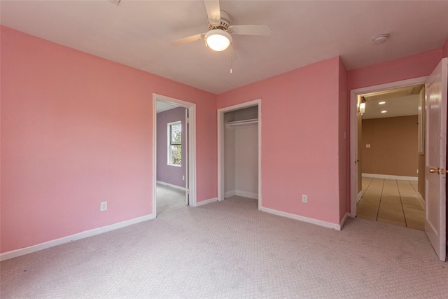 unfurnished bedroom featuring ceiling fan, light carpet, and a closet