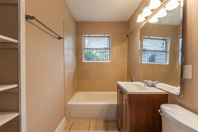 full bathroom with tiled shower / bath, tile patterned flooring, vanity, and toilet