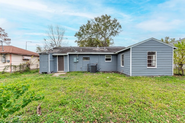 back of property featuring a lawn and central AC unit