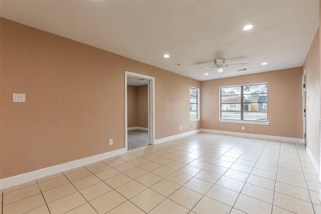 spare room with ceiling fan and light tile patterned floors