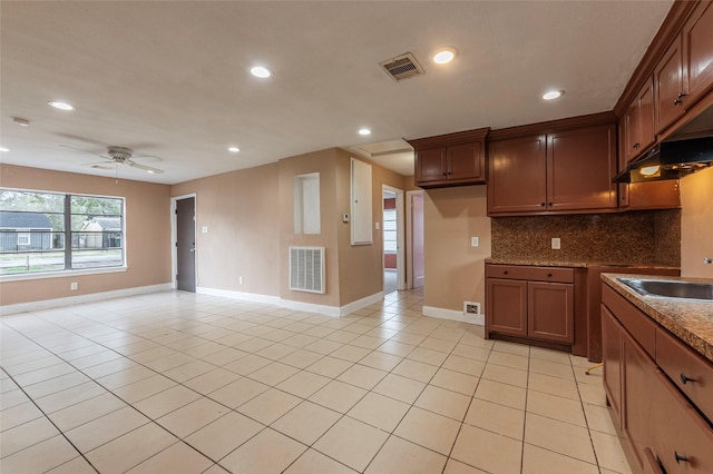 kitchen featuring backsplash, dark stone counters, sink, ceiling fan, and light tile patterned floors