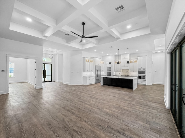 unfurnished living room with beamed ceiling, dark hardwood / wood-style floors, coffered ceiling, and sink