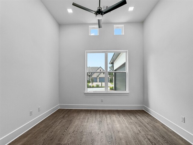 spare room with ceiling fan, plenty of natural light, and dark wood-type flooring