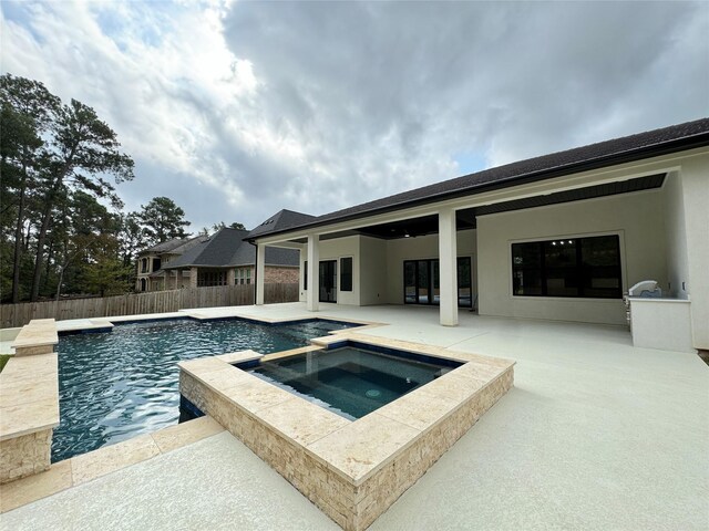 view of swimming pool featuring an in ground hot tub and a patio