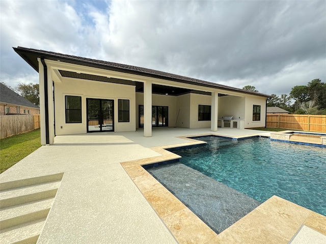 view of swimming pool with grilling area, an in ground hot tub, and a patio